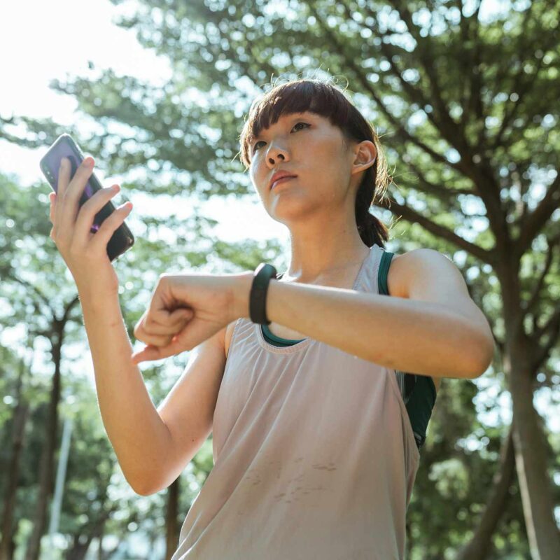 A woman using an AI exercise app and a connected watch